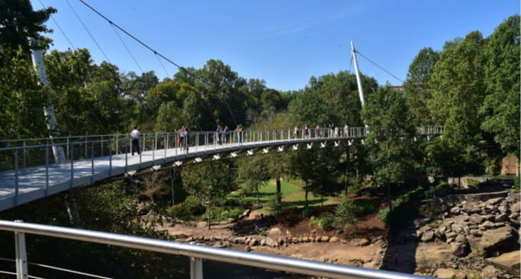People walking across the bridge at Falls Park