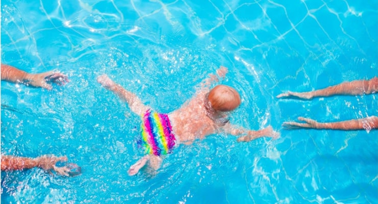Baby swimming from one adult to another