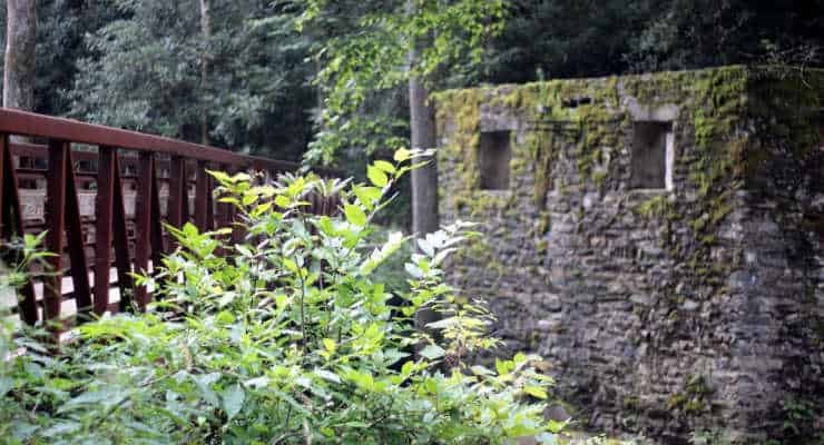 A metal bridge and an old stone structure at Catawba Falls Trail.
