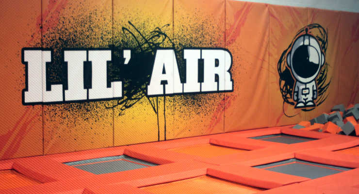 Trampoline pads with orange bumpers and a "Lil' Air" graphic on the wall