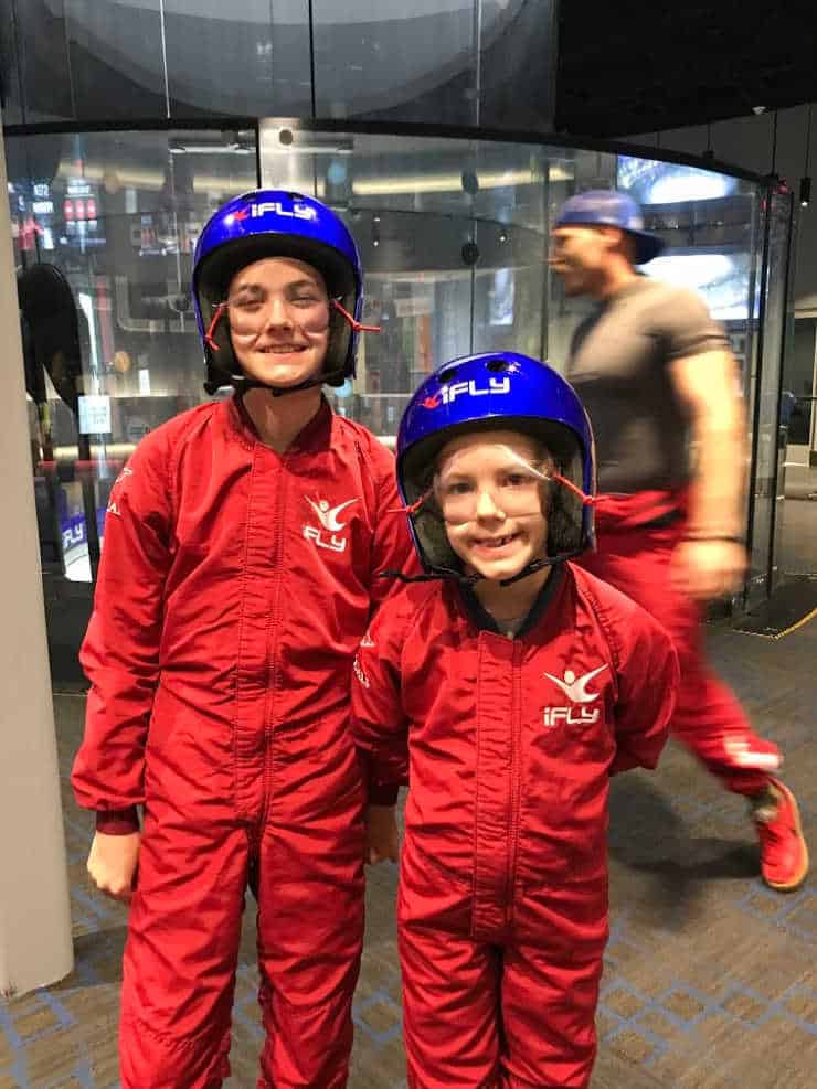 Two children in iFly suits, ready to indoor skydive.