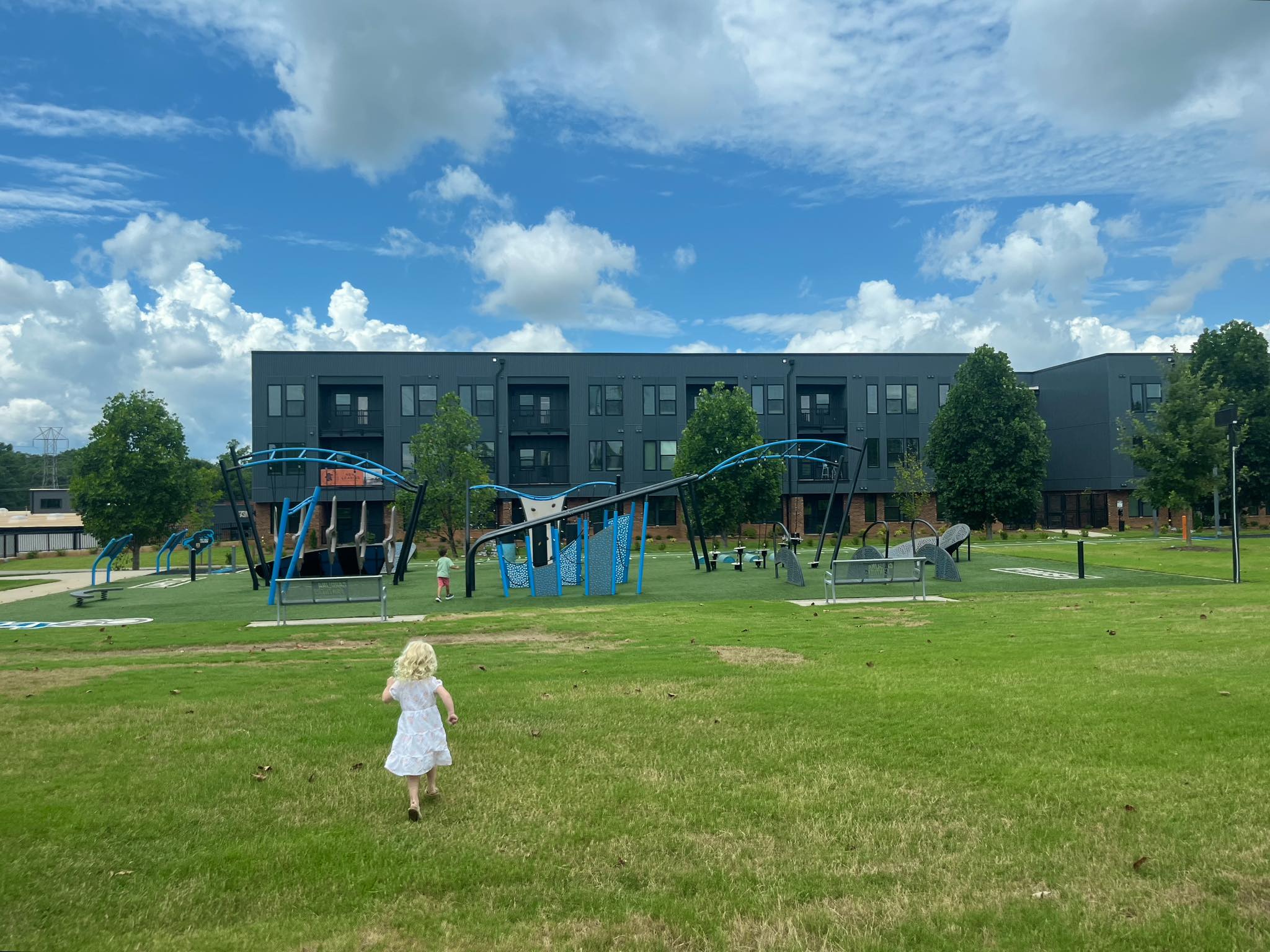Children running towards Panthers Play60 Playground at Rail Yard Community Park in Spartanburg, SC.