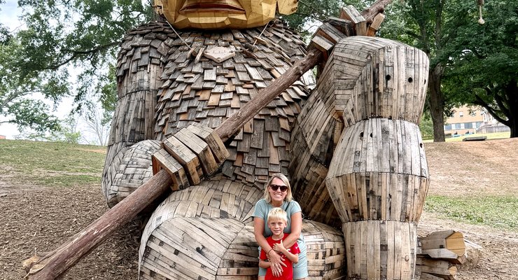 Rebecca and Cade posing with the Daddy Bird Eye giant troll sculpture at Dorothea Dix Park Raleigh NC