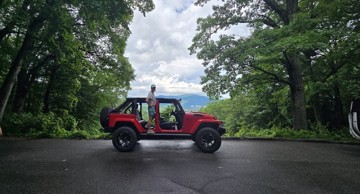 Red Jeep Wrangler with doors off parked at a scenic overlook in the Smoky Mountains near Gatlinburg, TN