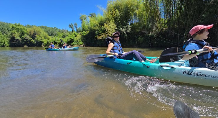 Kayakers paddling the scenic French Broad River near Rosman NC with clear water and mountain views