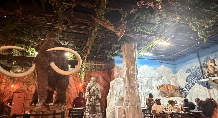 Family with animatronic dinosaur at DinoLand Cafe in Myrtle Beach