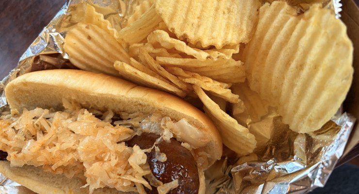 Squire's Bratwurst with sauerkraut in a toasted bun and chips from Fae Nectar Celtic Kitchen