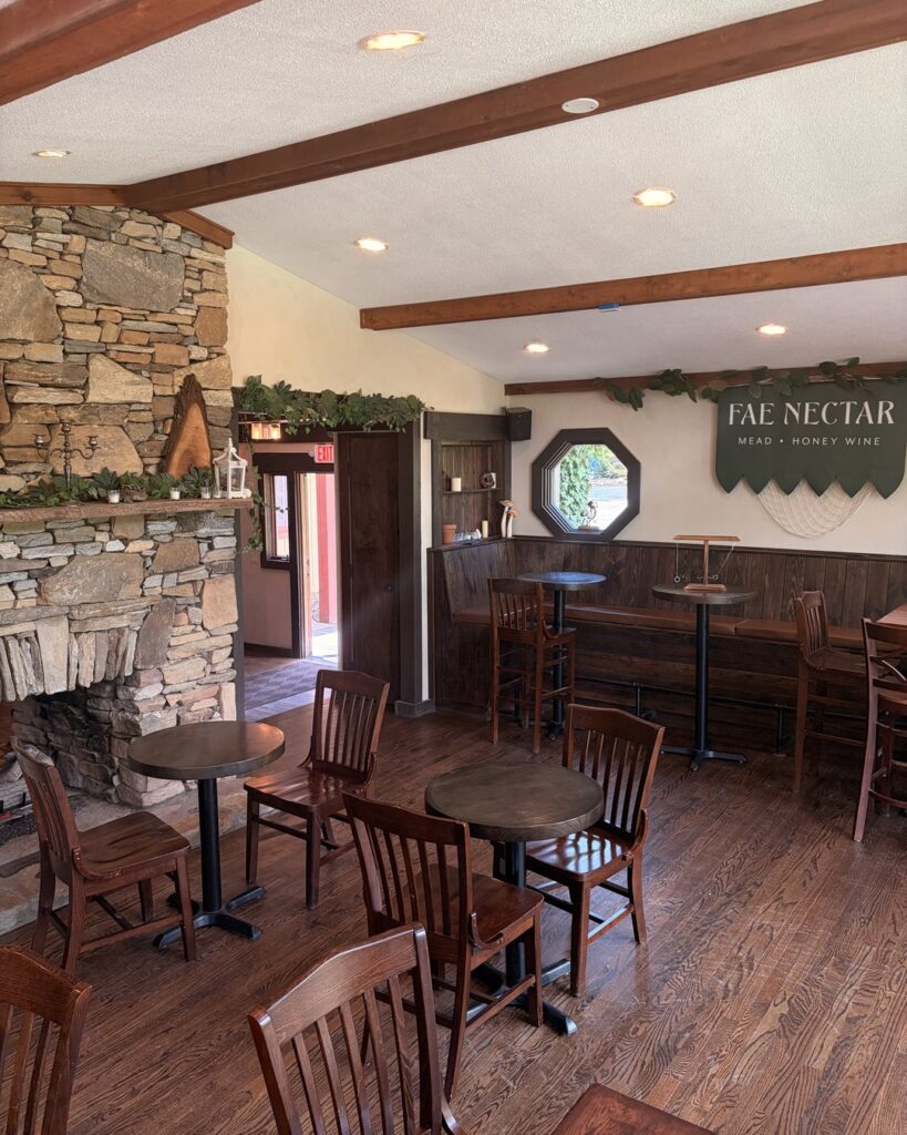 Fae Nectar taproom interior showing wooden tables and the Fae Nectar Mead Honey Wine sign on the wall