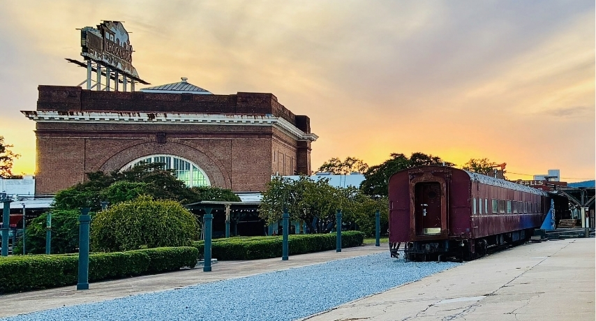The sun sets behind Terminal Station with a large Choo Choo sign overhead