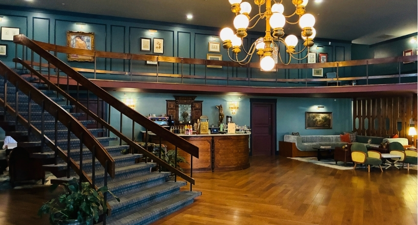 An elegant hotel lobby with grand staircase and chandelier