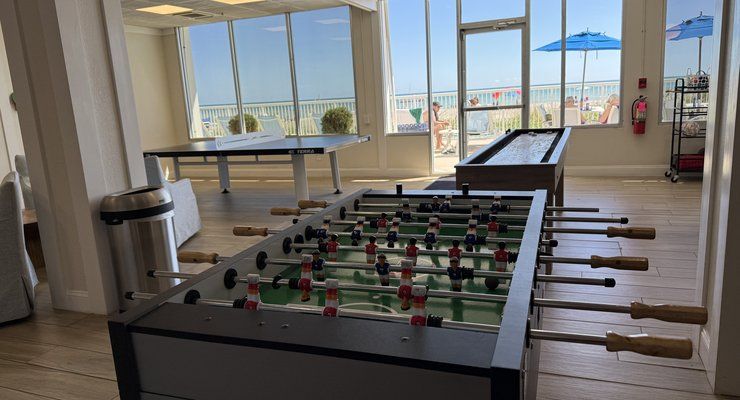 Game room with foosball and ping pong tables and windows overlooking the beach at Westgate Myrtle Beach Oceanfront Resort