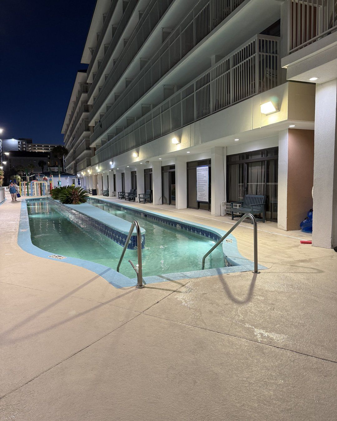 Heated lazy river at Westgate Myrtle Beach Oceanfront Resort lit up at night beside the hotel building