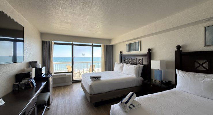 Two queen beds and a balcony door overlooking the ocean in an oceanfront room at Westgate Myrtle Beach Oceanfront Resort